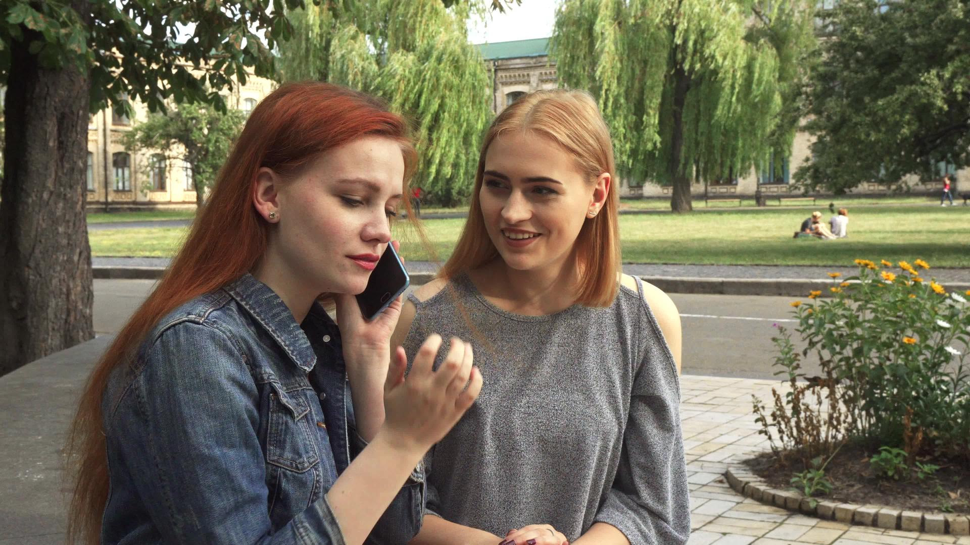 两个女孩在同一个电话上说话视频的预览图