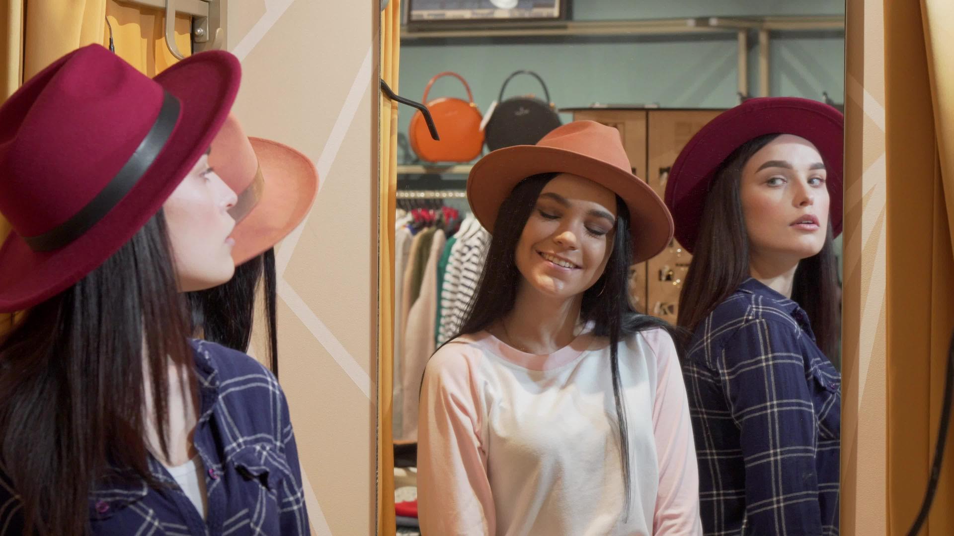 两个可爱的年轻女士一起买东西时试着戴帽子视频的预览图