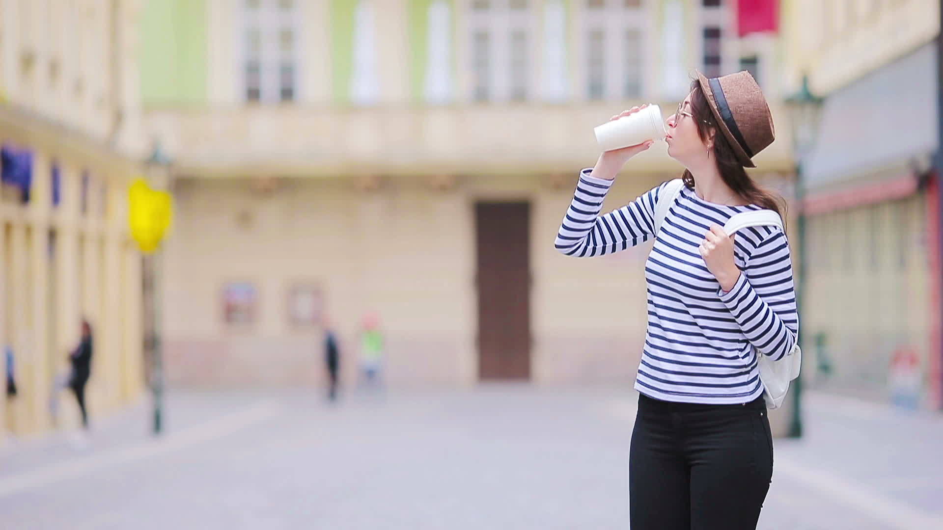 快乐的年轻都市女性在欧洲城市的荒凉街道上行走视频的预览图