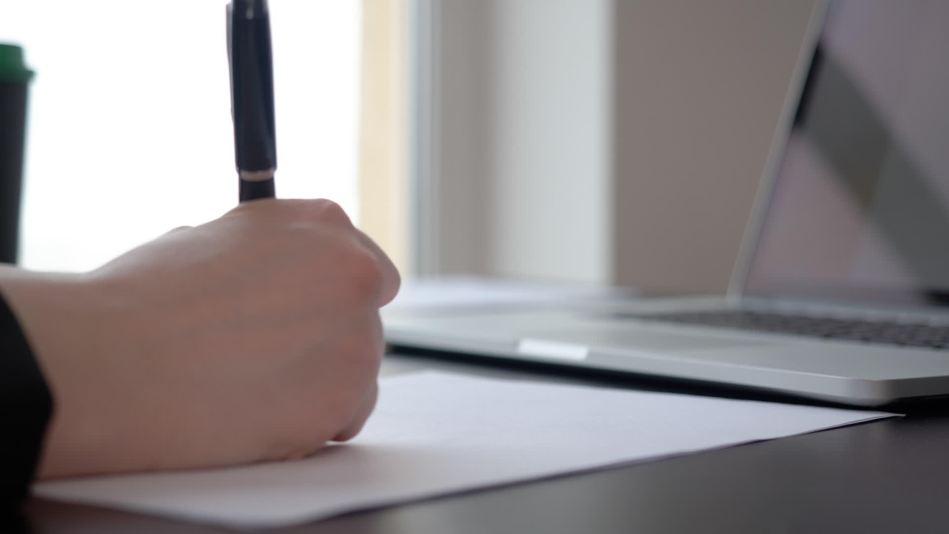 女性手写文档笔放在膝盖电脑背景调查的工作台上视频的预览图