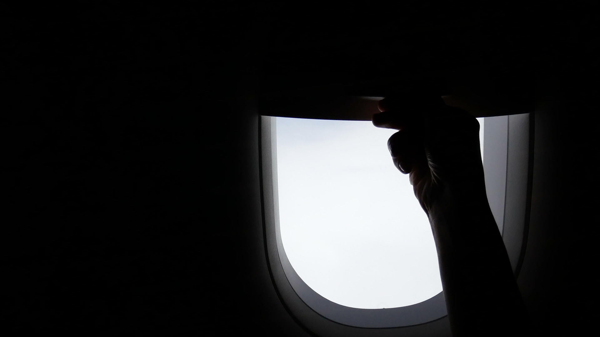 乘飞机旅行的年轻女孩的手在空中旅行时向上滑动视频的预览图