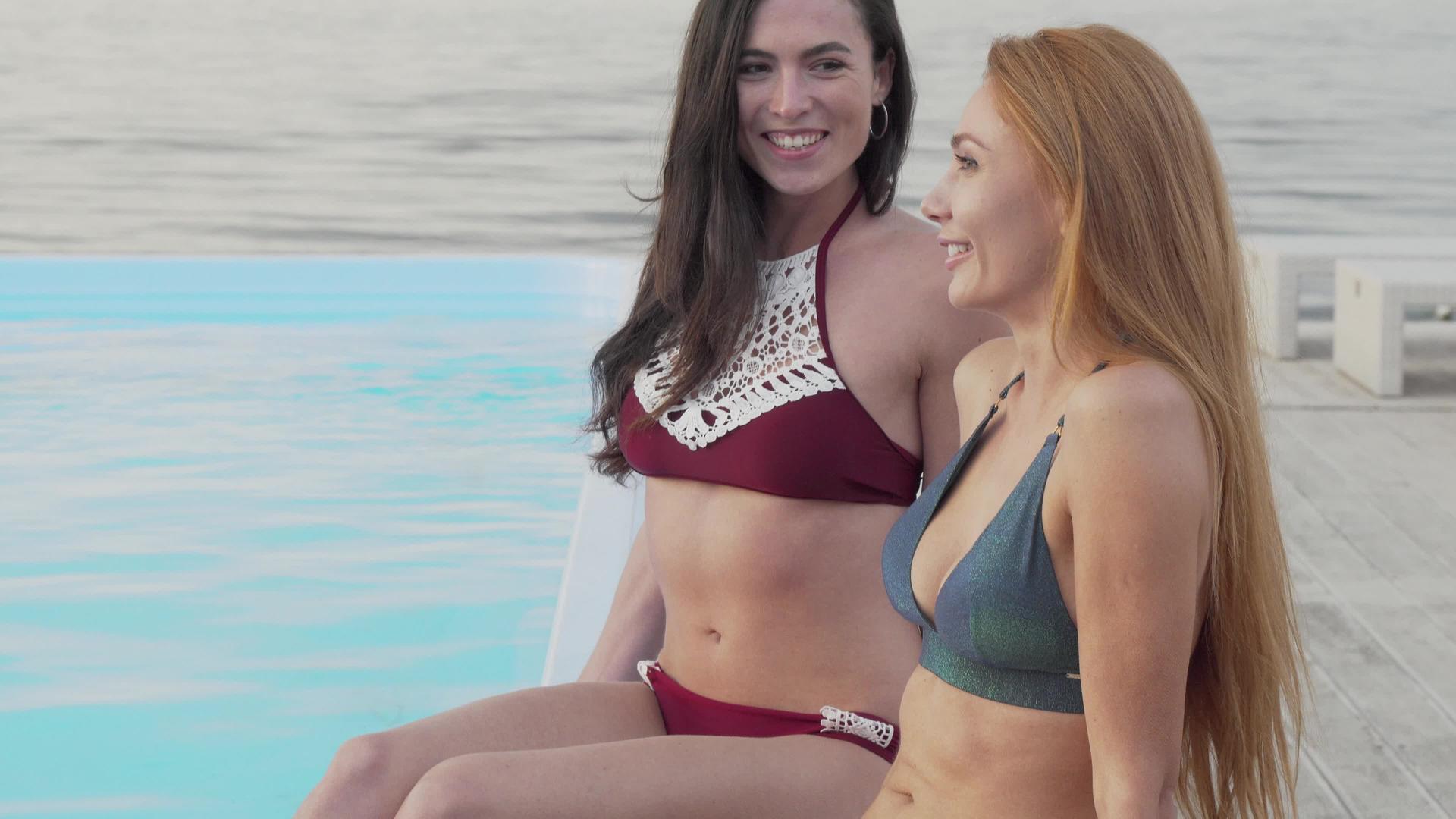 两个快乐的女朋友在游泳池边聊天休息时聊天视频的预览图