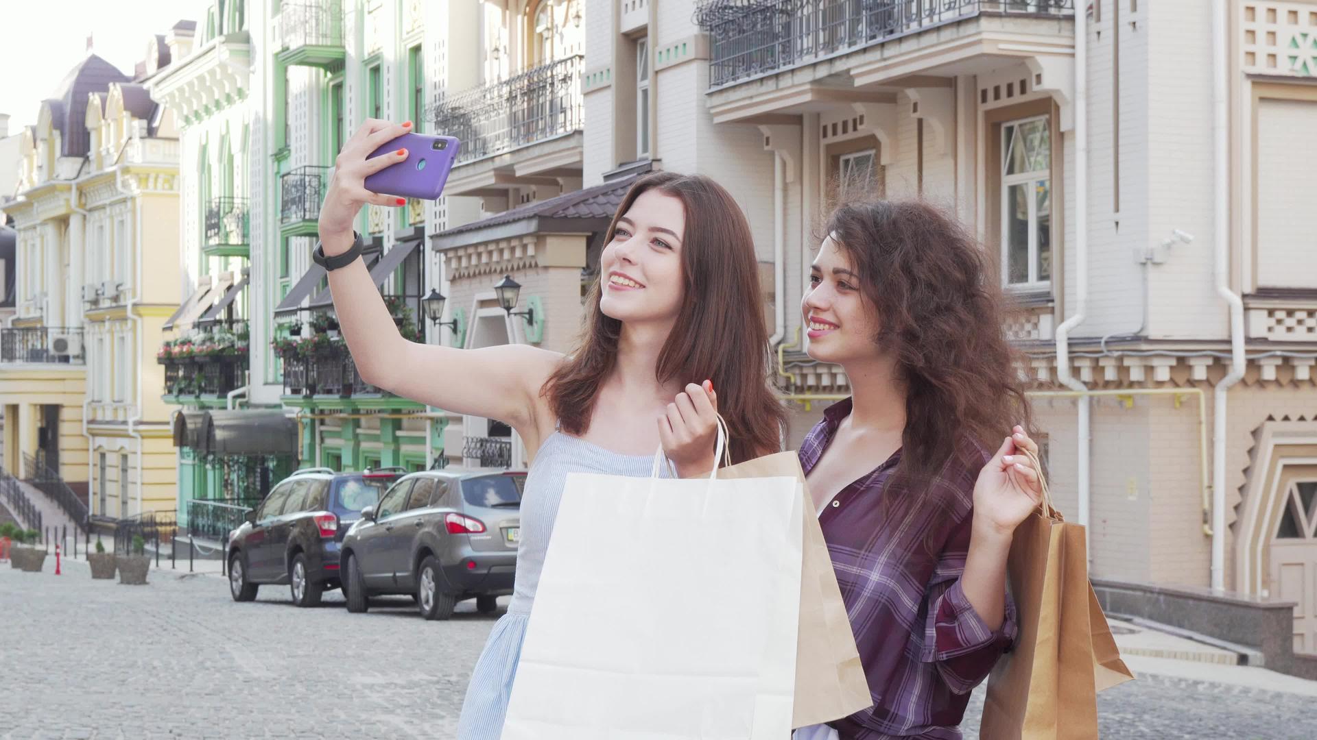 可爱的女性朋友购物后在智能手机上自拍视频的预览图
