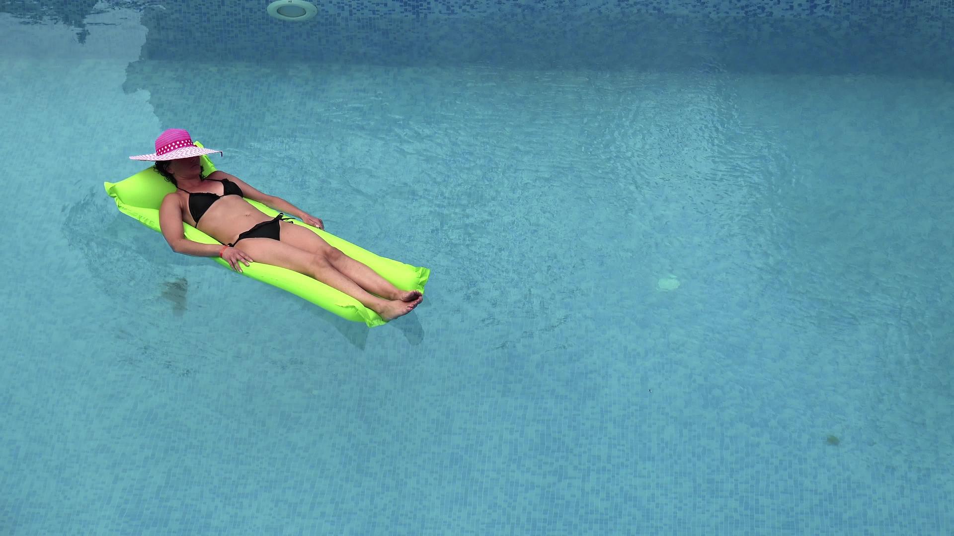 快乐的海滩女孩漂浮在游泳池的水中在海洋度假胜地的水中视频的预览图