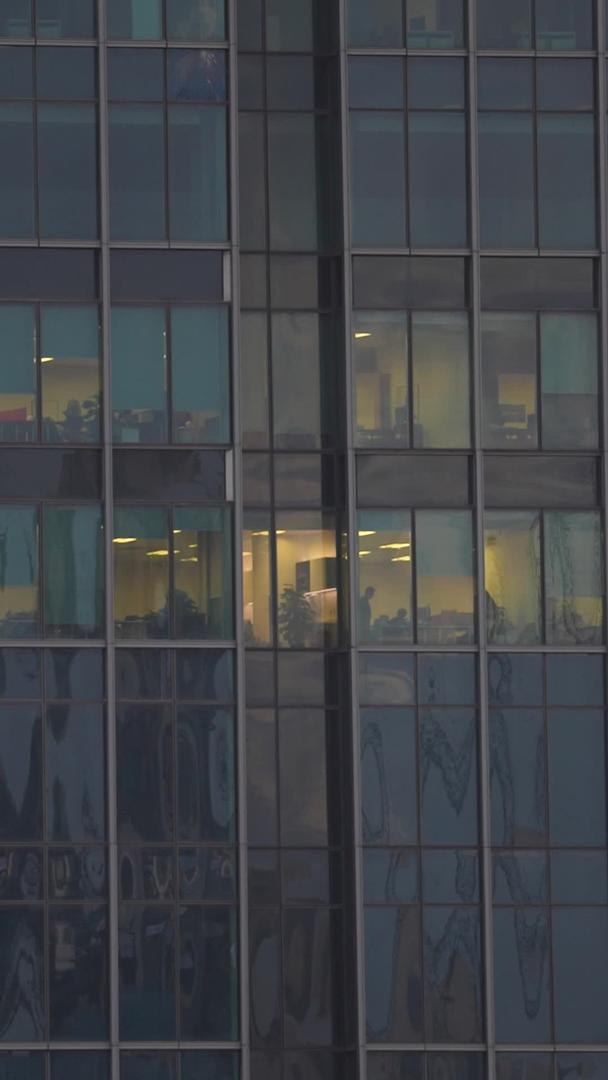 航拍城市办公楼夜景灯火通明的办公室加班材料视频的预览图