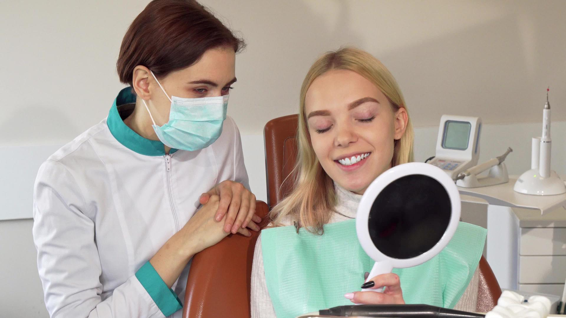 专业牙医和她的病人对着相机微笑视频的预览图