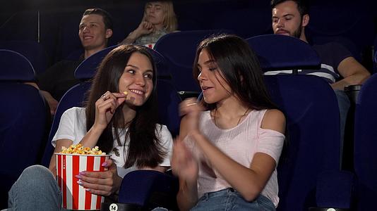 年轻漂亮的女人在电影院看电影视频的预览图