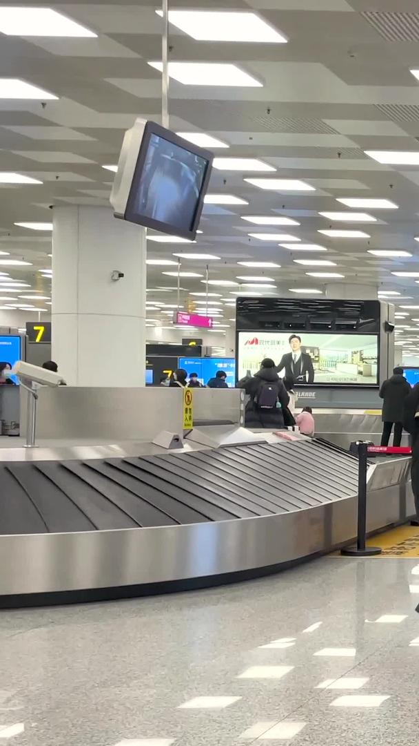 郑州新郑国际机场T2航站楼穿着防护服拉着行李箱出站的旅客视频的预览图