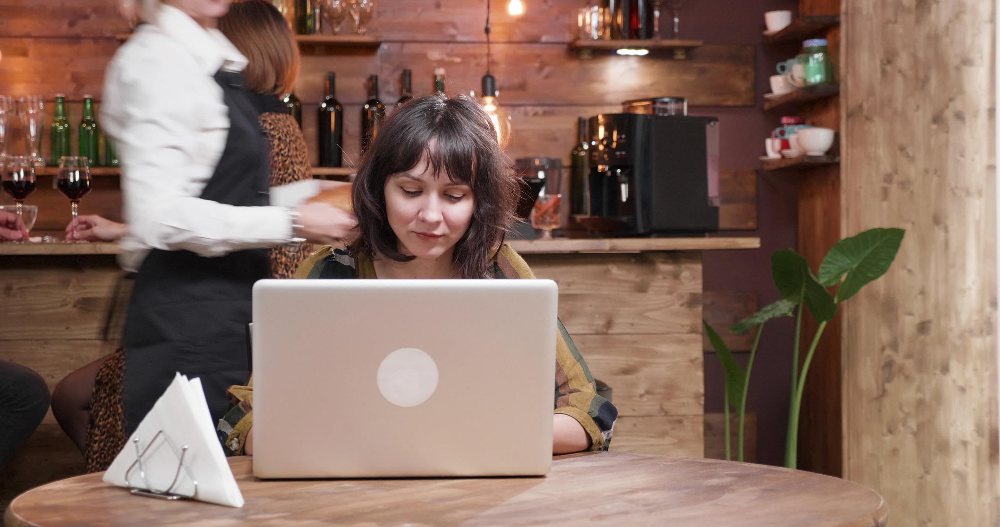 这个漂亮的女孩在她的电脑上打字在咖啡店喝咖啡视频的预览图