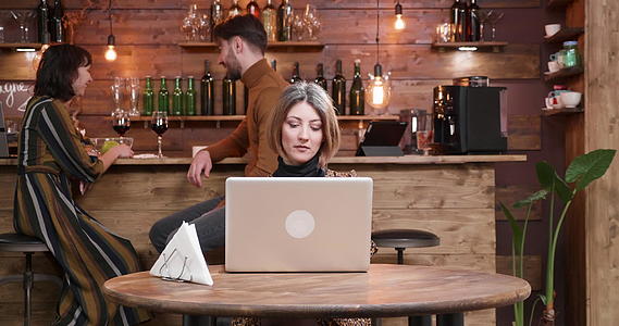 女人在老式咖啡馆用笔记本电脑工作时喝咖啡视频的预览图