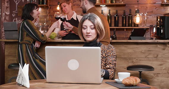 女人用笔记本电脑打字人们在酒吧聊天视频的预览图