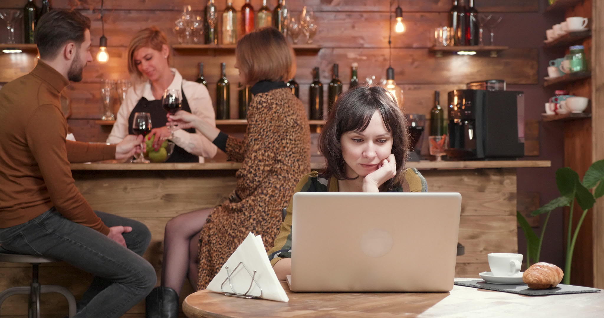 一家餐馆的年轻女子在笔记本电脑上看短信视频的预览图