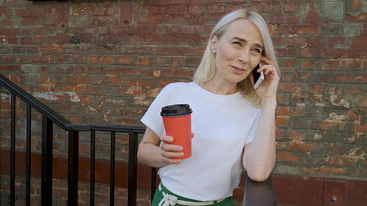一个美丽的女人拿着一杯红咖啡和你的男朋友聊天视频的预览图