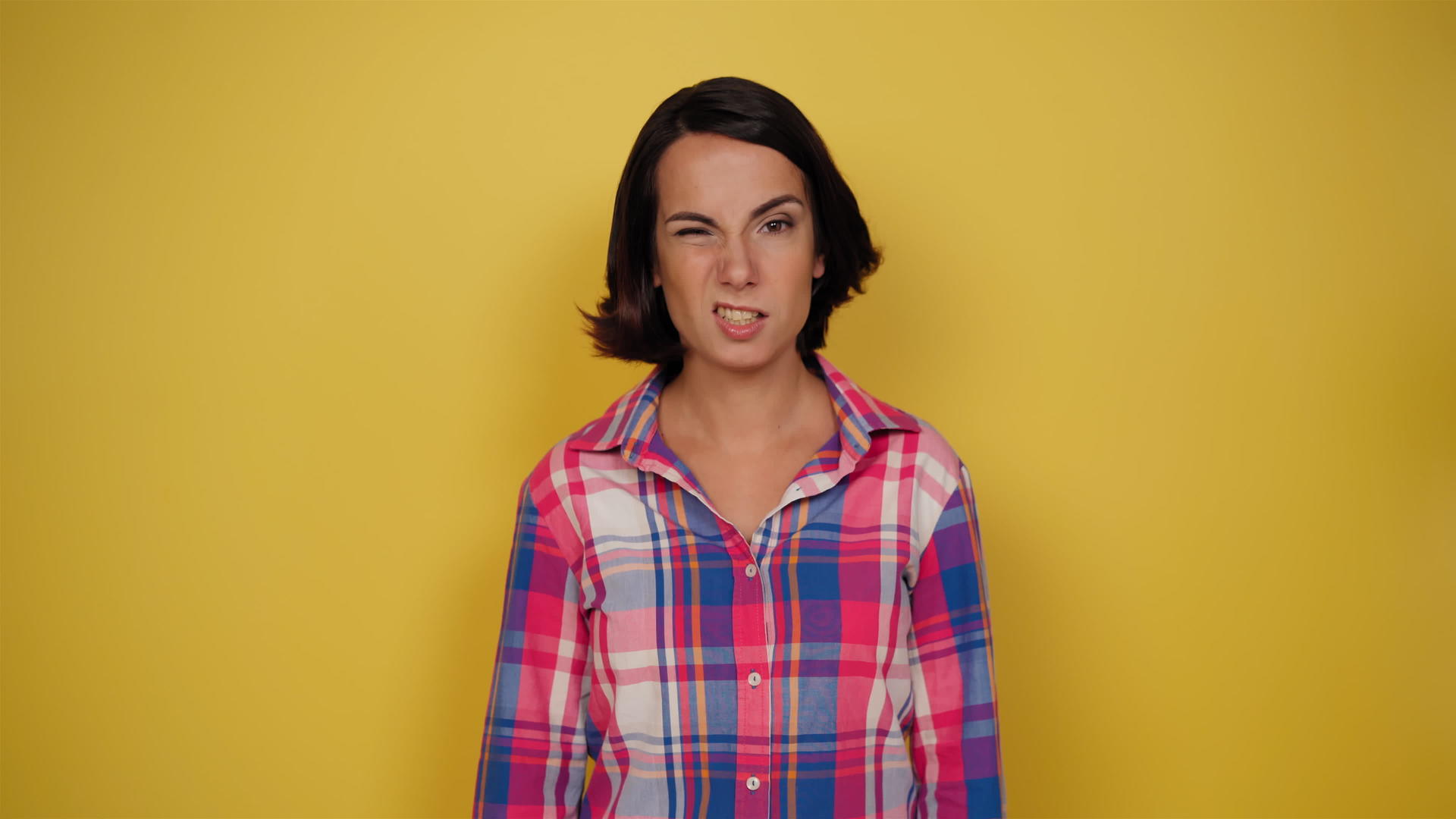 穿着黄色背景格子衬衫的女性有利于人类的面部表情视频的预览图