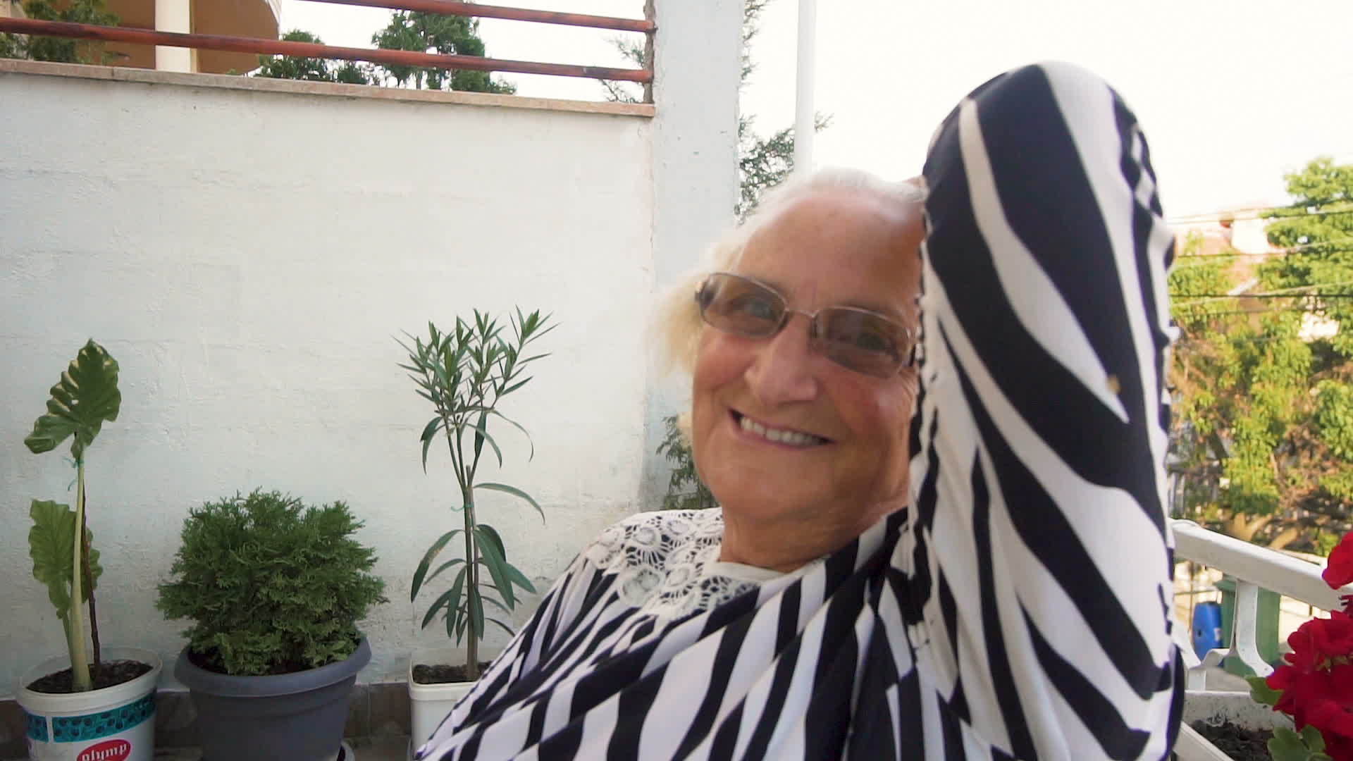 快乐的老女人的肖像看着镜头做她的发型慢动作视频的预览图