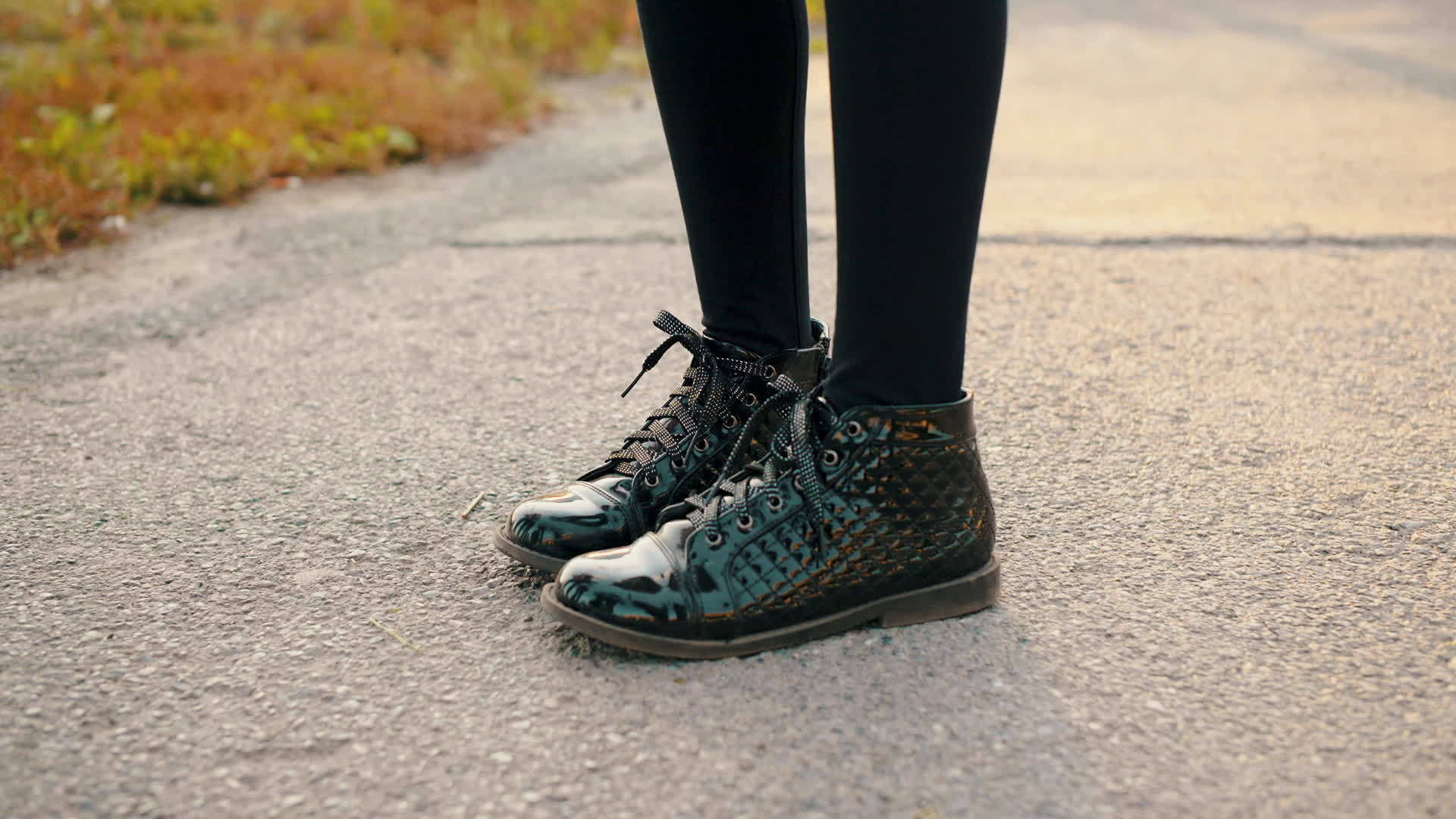 穿着漆皮鞋的女人站在柏油路上视频的预览图