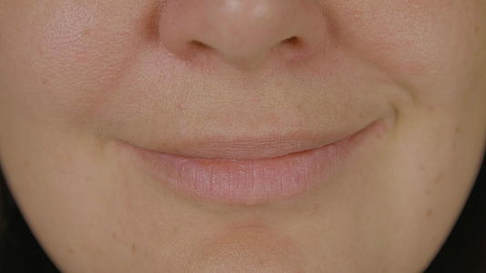 女性的脸、嘴和微笑的嘴唇靠近微笑的女性的嘴唇和嘴巴视频的预览图