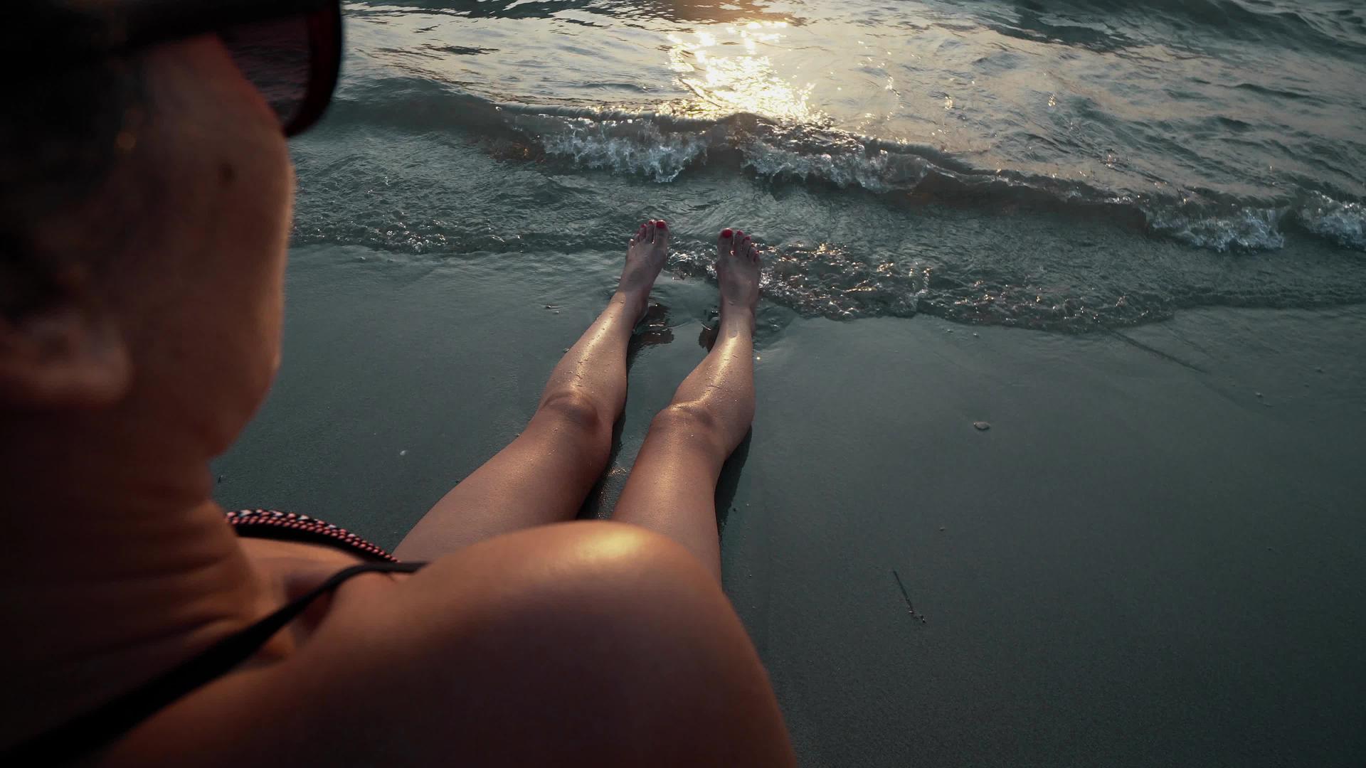 日落时分我坐在金沙海滩上看着海边的赤脚和腿视频的预览图