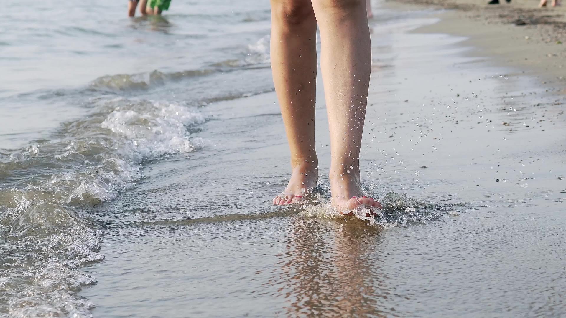 走在海边的女人被电影制片人的赤脚冲上了电影制片人Stadicam视频的预览图