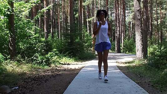 年轻女孩在森林公园慢跑视频的预览图