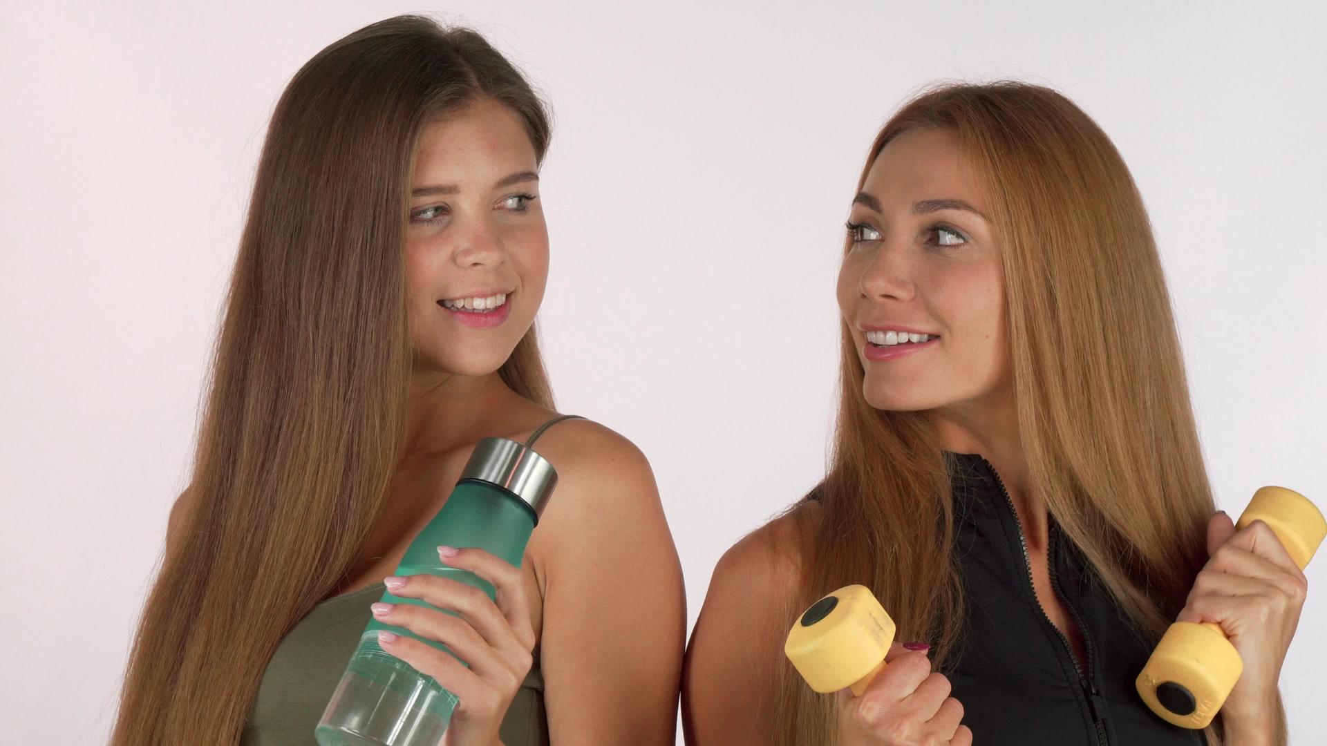 两个健身女孩在水瓶和哑铃微笑视频的预览图