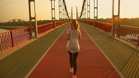 一个女人在桥的后面跑视频的预览图