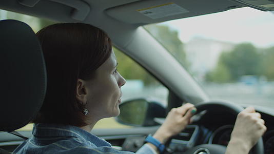 30岁的年轻女性在城市开车时跳舞唱歌女司机用手用手视频的预览图