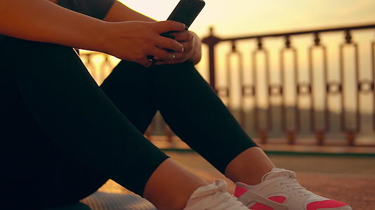 女孩在智能手机上使用健身应用软件视频的预览图