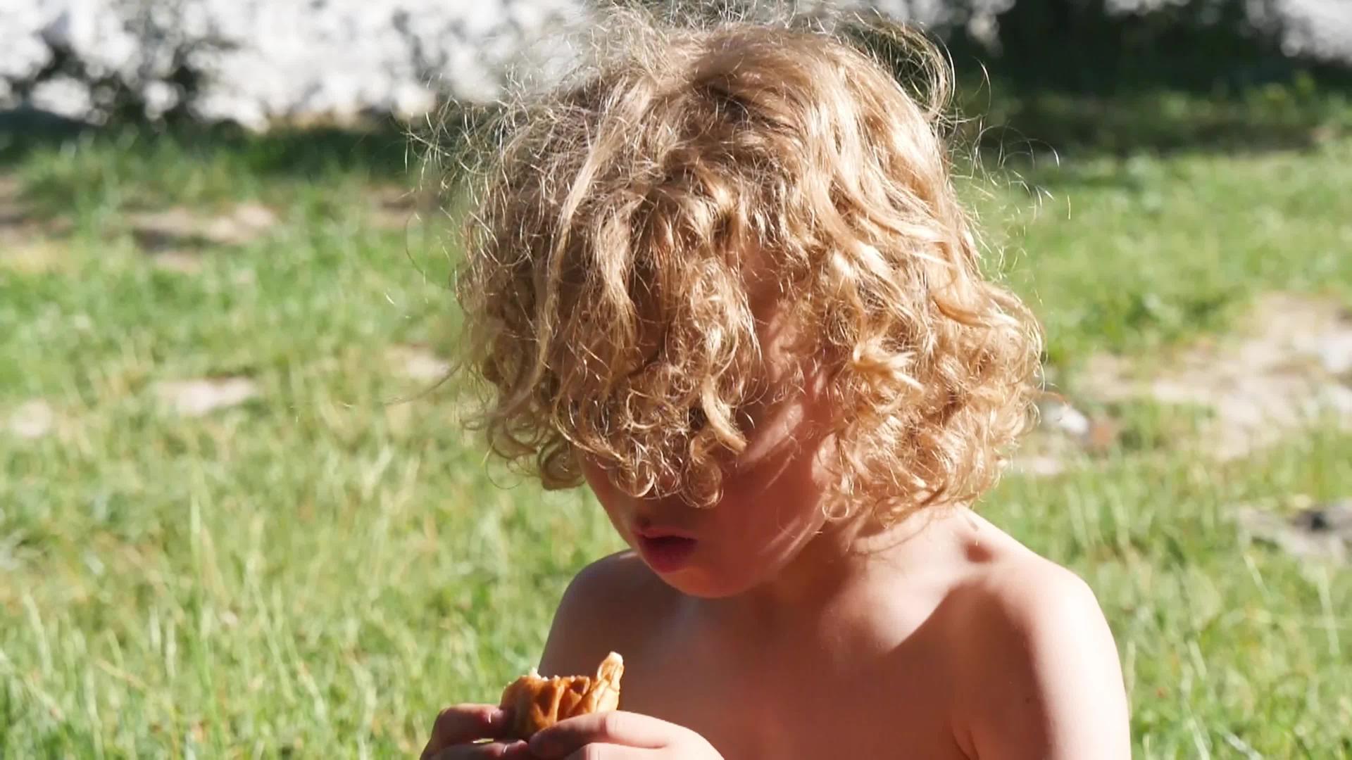 一个金发男孩在户外吃蛋糕视频的预览图