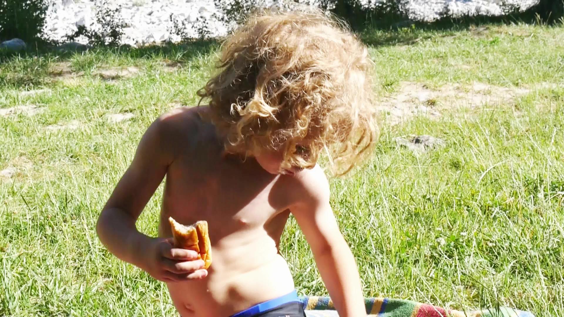 一个金发男孩在户外吃蛋糕视频的预览图
