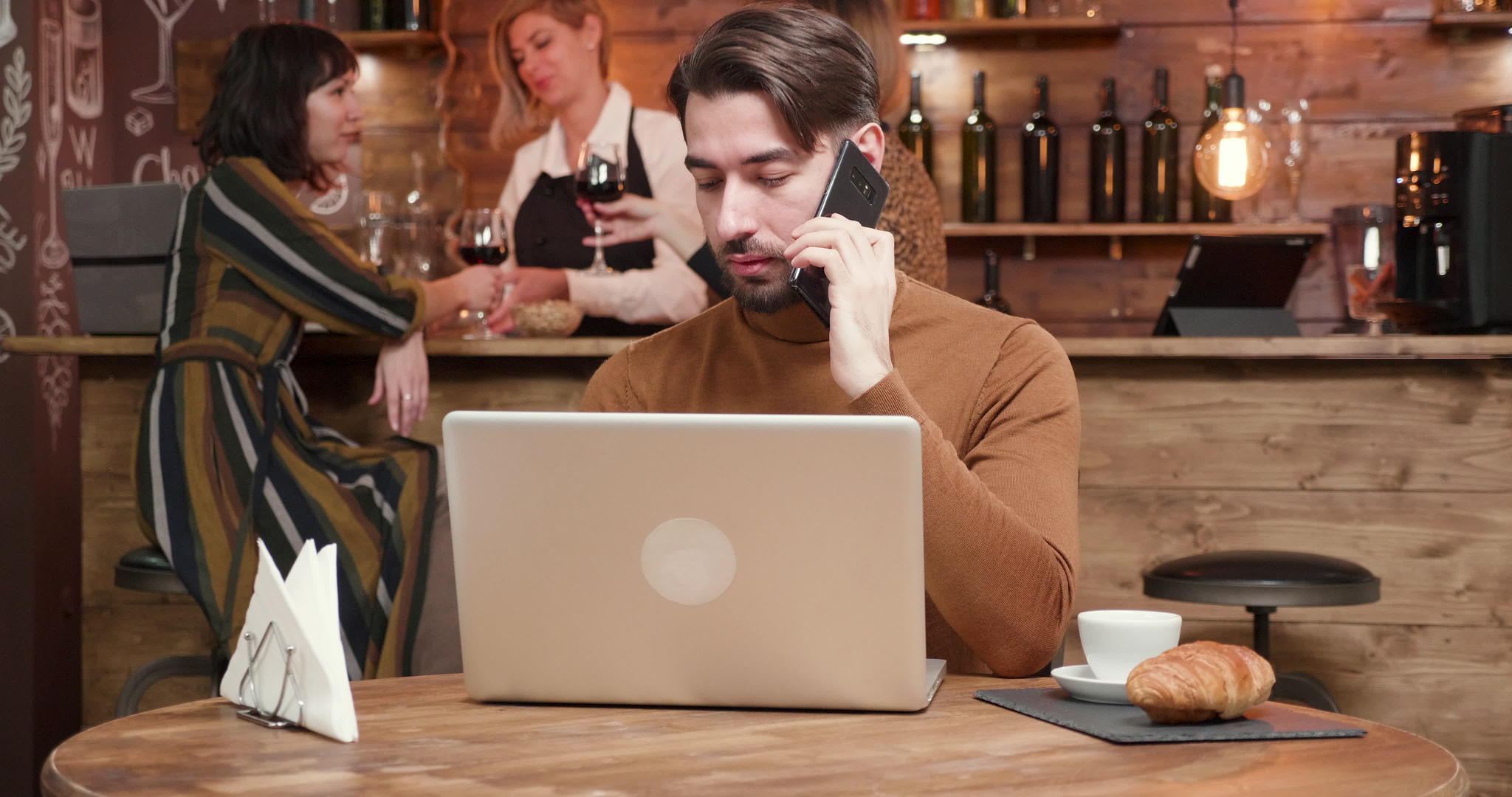 在酒吧工作时一位英俊的年轻商人在电话里讲话视频的预览图