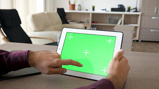 男人在数字平板电脑上工作用绿屏模拟视频的预览图