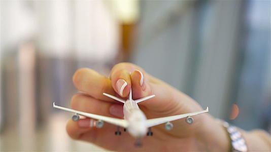 机场有小型飞机模型的女性手持玩具飞机复制文本空间视频的预览图
