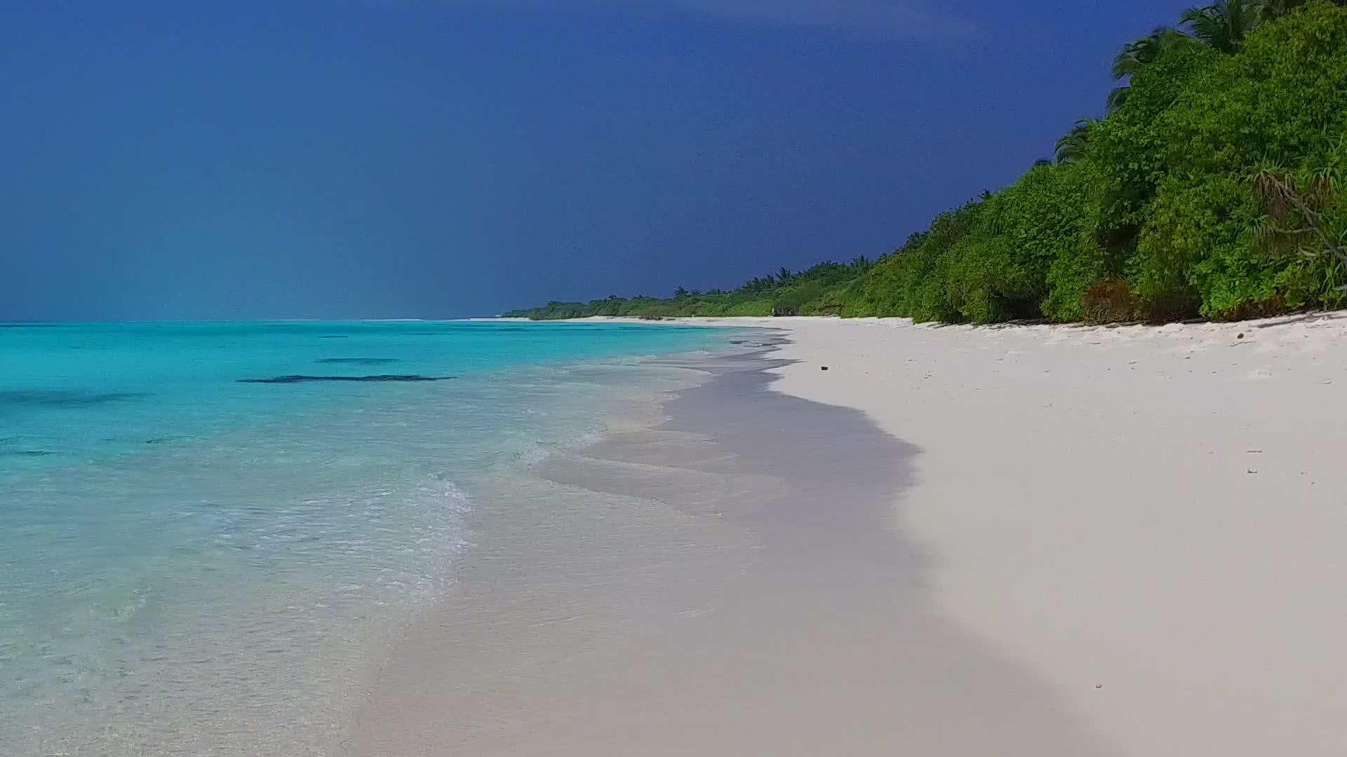 白色沙滩背景下的绿松石环礁湖在豪华岛屿海滩上冒险视频的预览图