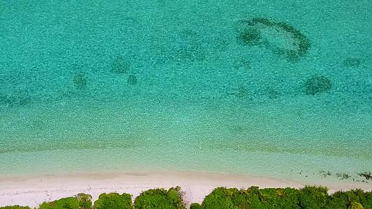 蓝色的海洋和日出后的白色沙滩美丽的海岸海滩航行空间视频的预览图