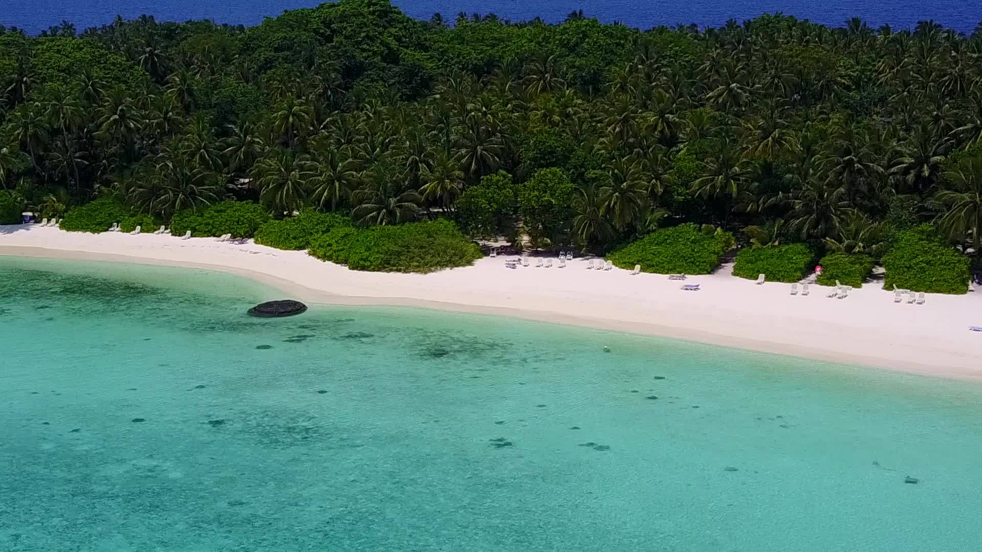 阳光明媚的蓝色环礁湖和阳光下白色沙滩的美丽背景视频的预览图