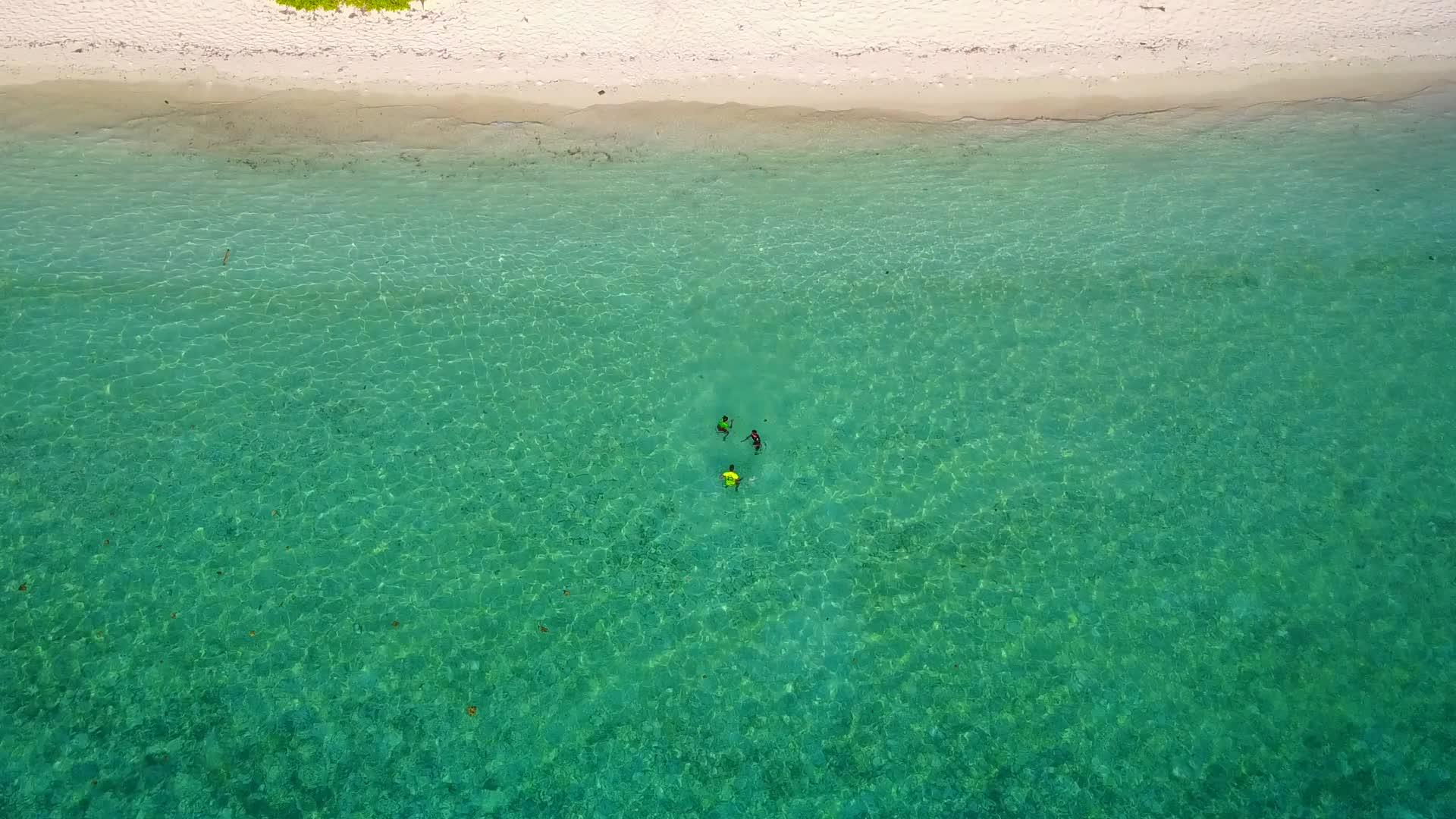 在阳光下绿松石环礁形成了一个平静的海滩视频的预览图