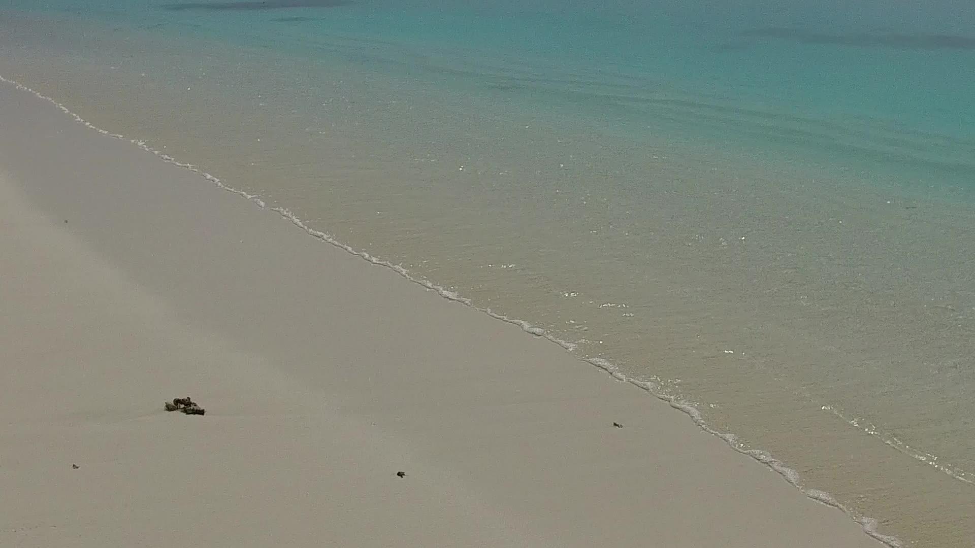 通过透明的水和靠近度假胜地的白沙背景使安静的海岸线靠近海岸视频的预览图