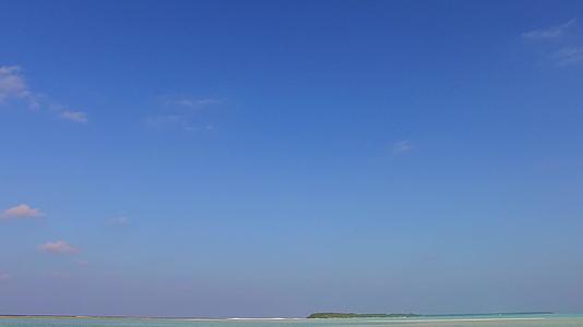日出后蓝海和白沙本背景的蓝色海滨海滩假日宽角视频的预览图