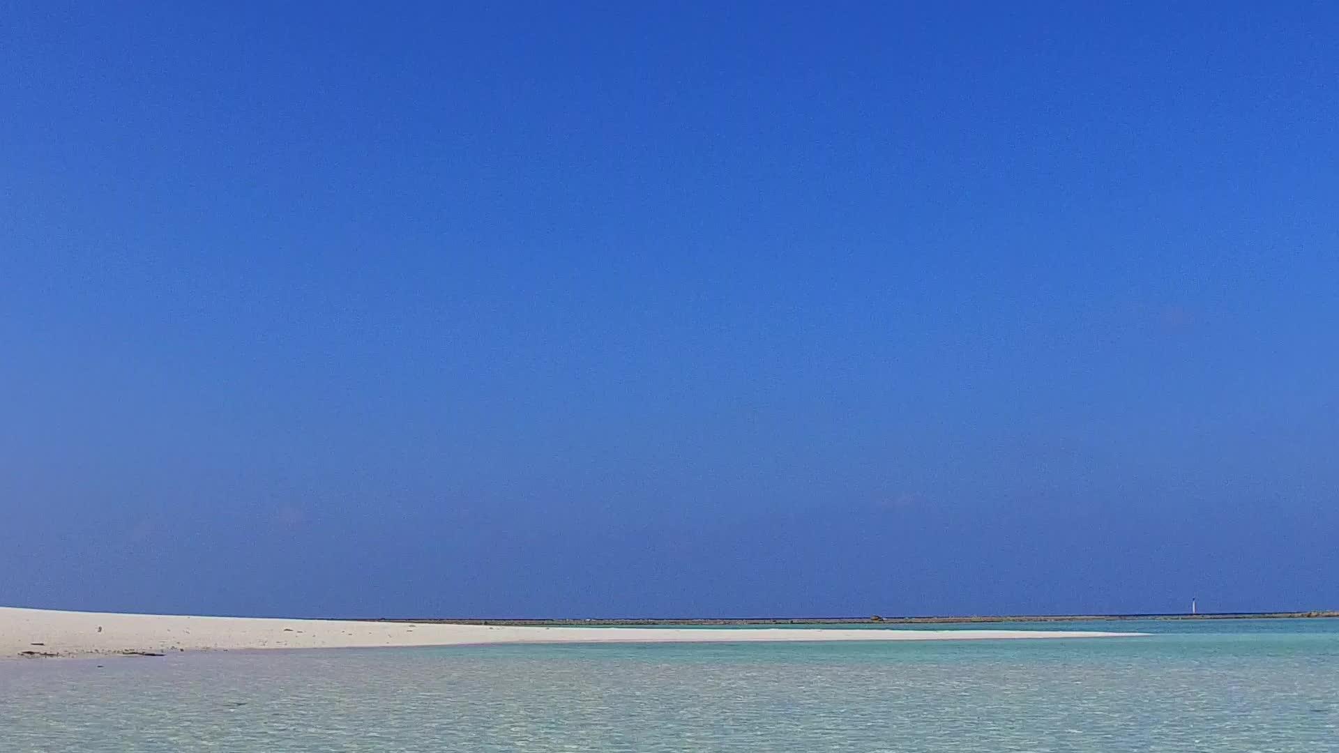 豪华度假村通过水蓝色海洋和冲浪附近的白色海滩背景复制视频的预览图