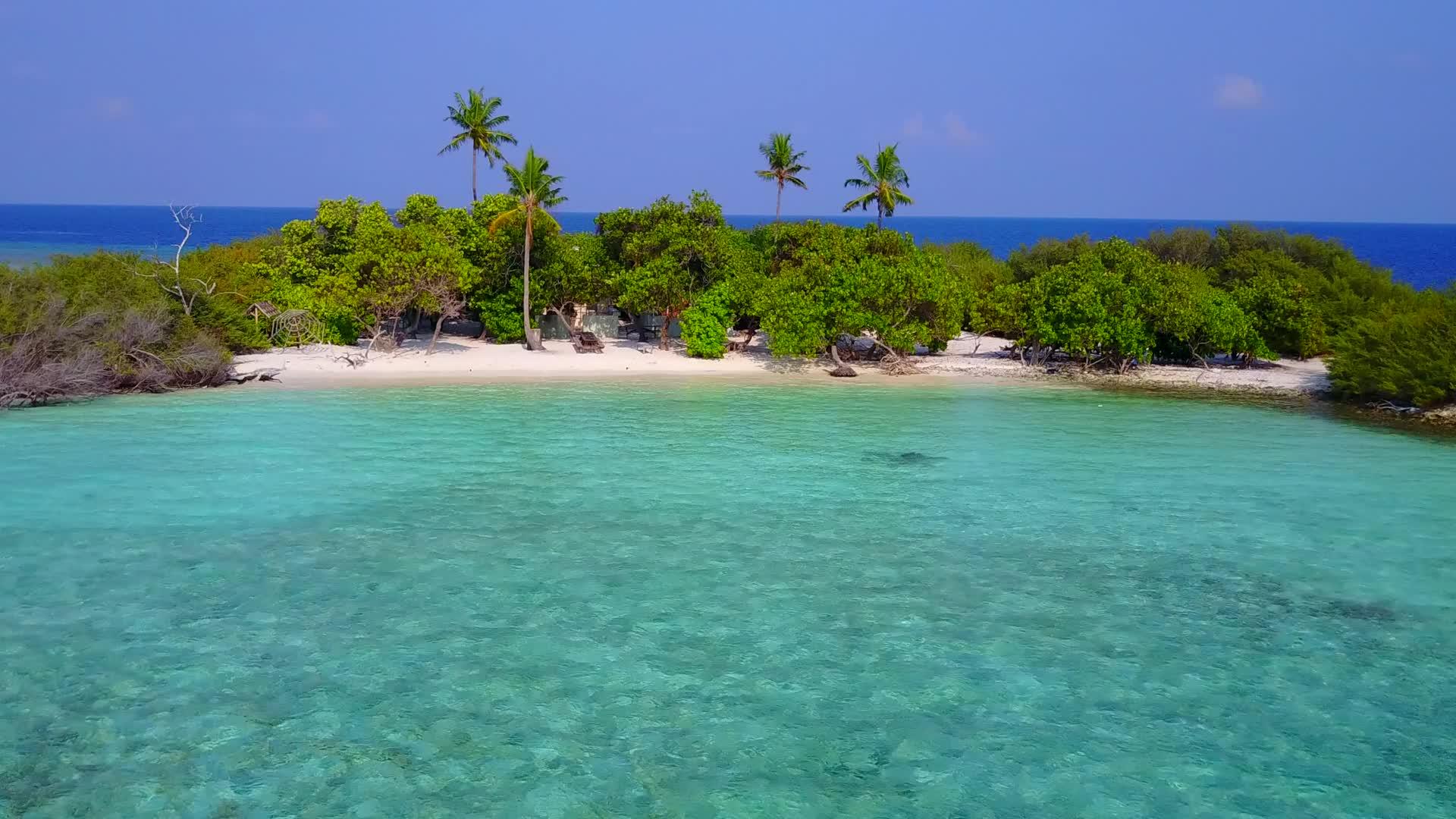 蓝色环礁湖和浅沙背景靠近度假胜地热带海滩度假日视频的预览图