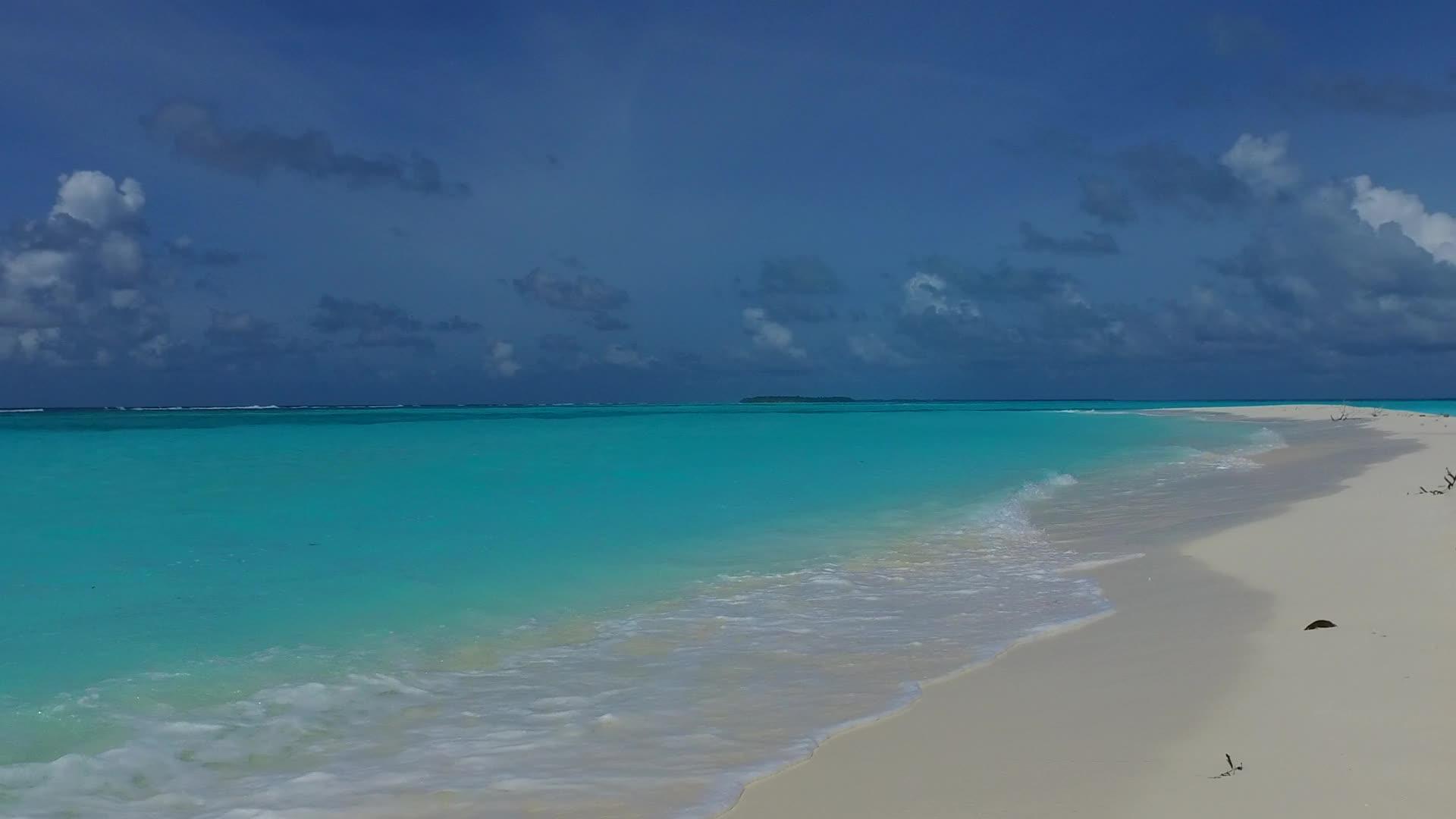 从宽角中提取蓝绿色海洋和接近度假胜地的白色沙沙背景视频的预览图