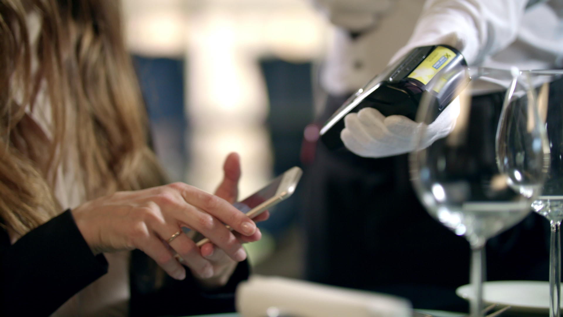 女性用手在餐厅通过移动电话支付账单视频的预览图