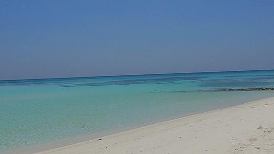 蓝色的水和接近冲浪的白色沙滩背景的蓝色水和白色的沙子冒险视频的预览图