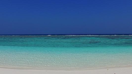蓝海中断的海滩在珊瑚礁附近有一个白色的沙底背景视频的预览图