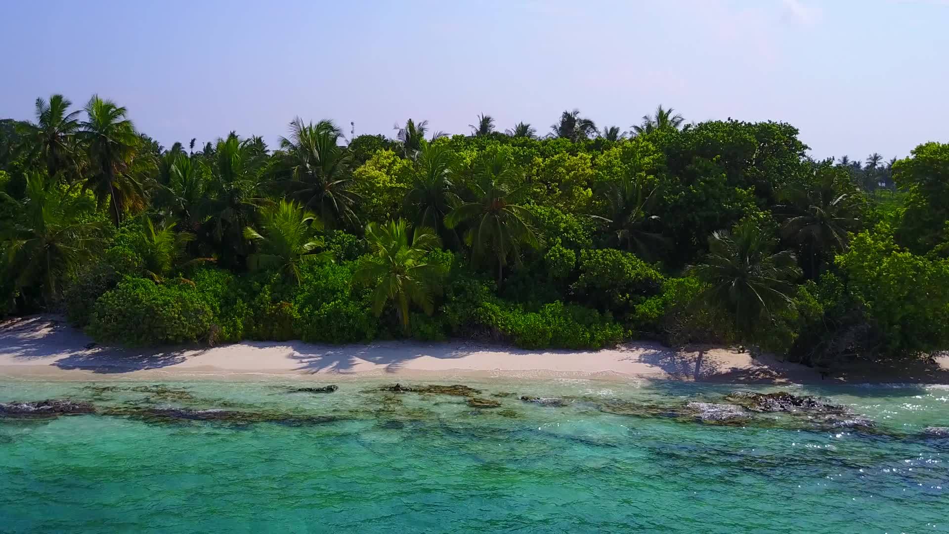 蓝绿色海洋和珊瑚礁附近的白沙背景海洋海滩度假开放景观视频的预览图