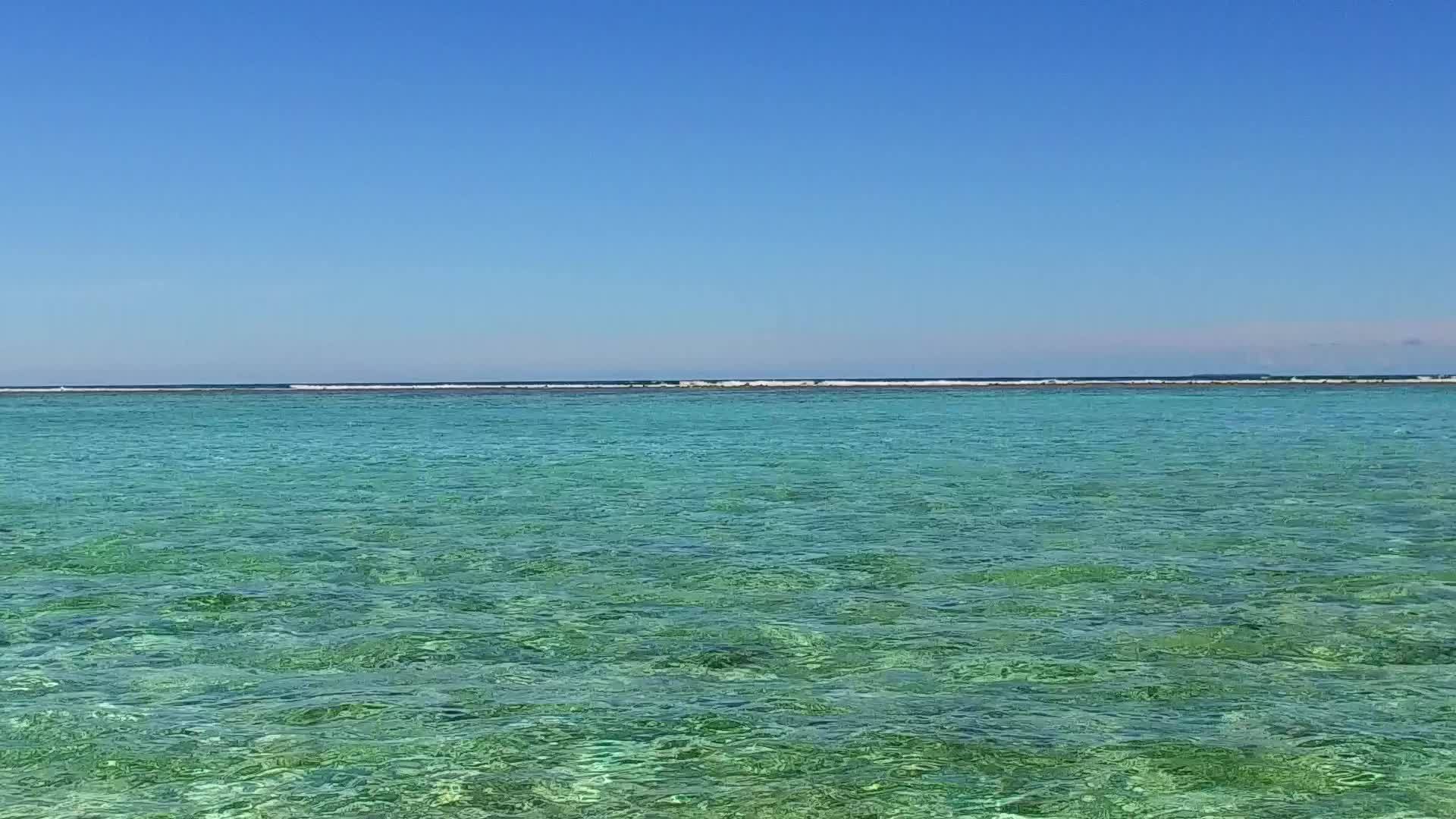 以蓝色环礁湖为例在阳光下清理沙土背景在宁静的海滩上巡游视频的预览图