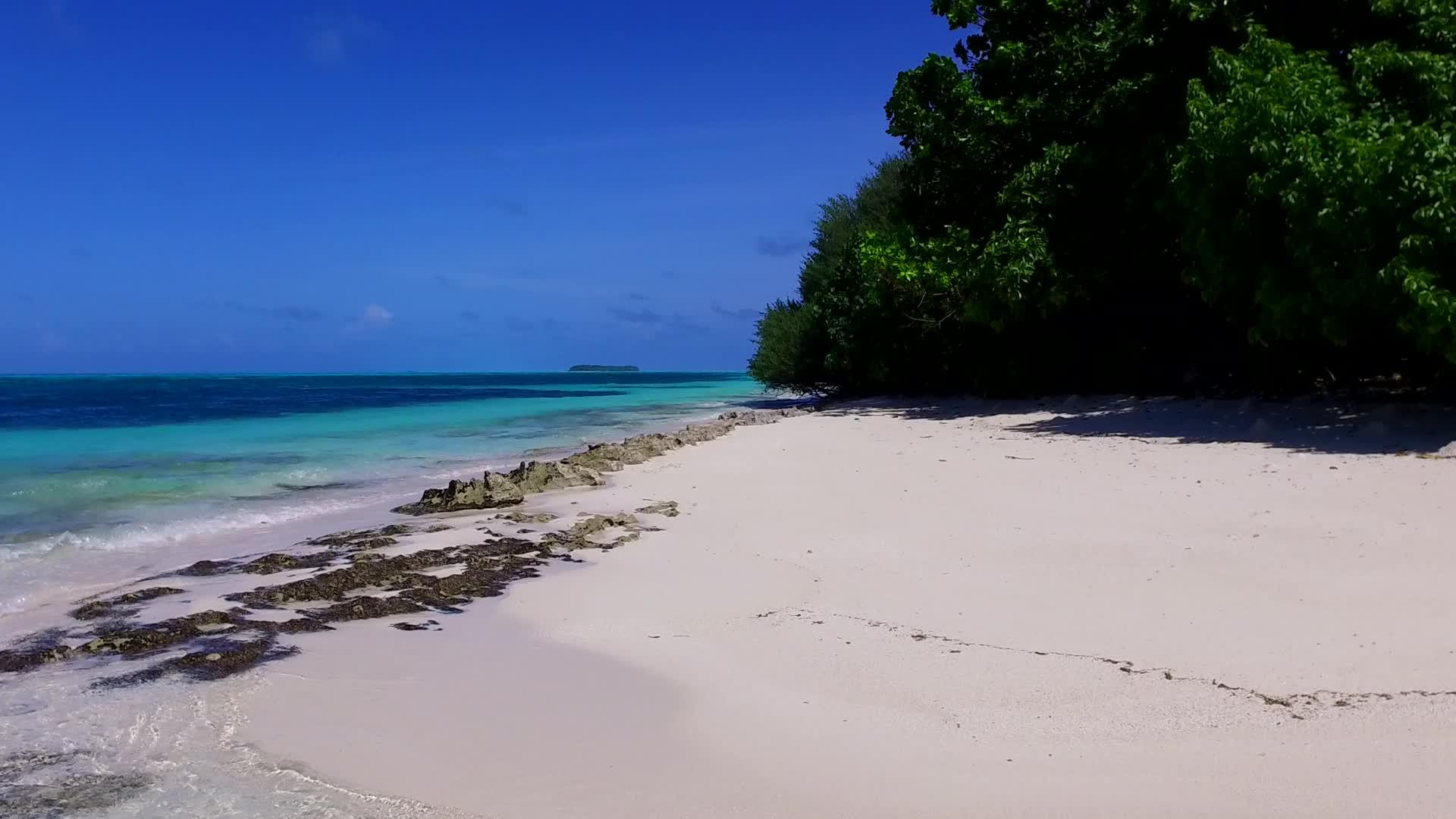 在海浪附近用白沙背景的蓝绿水复制放松海滩海滩的空间视频的预览图