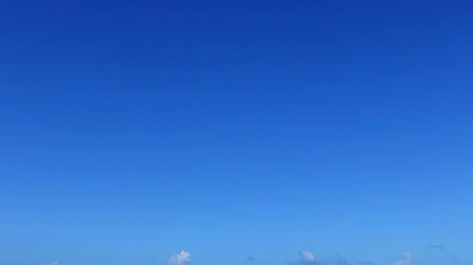 蓝色的海面上有一个安静的旅游海滩棕榈树附近有一个白色的沙底背景视频的预览图