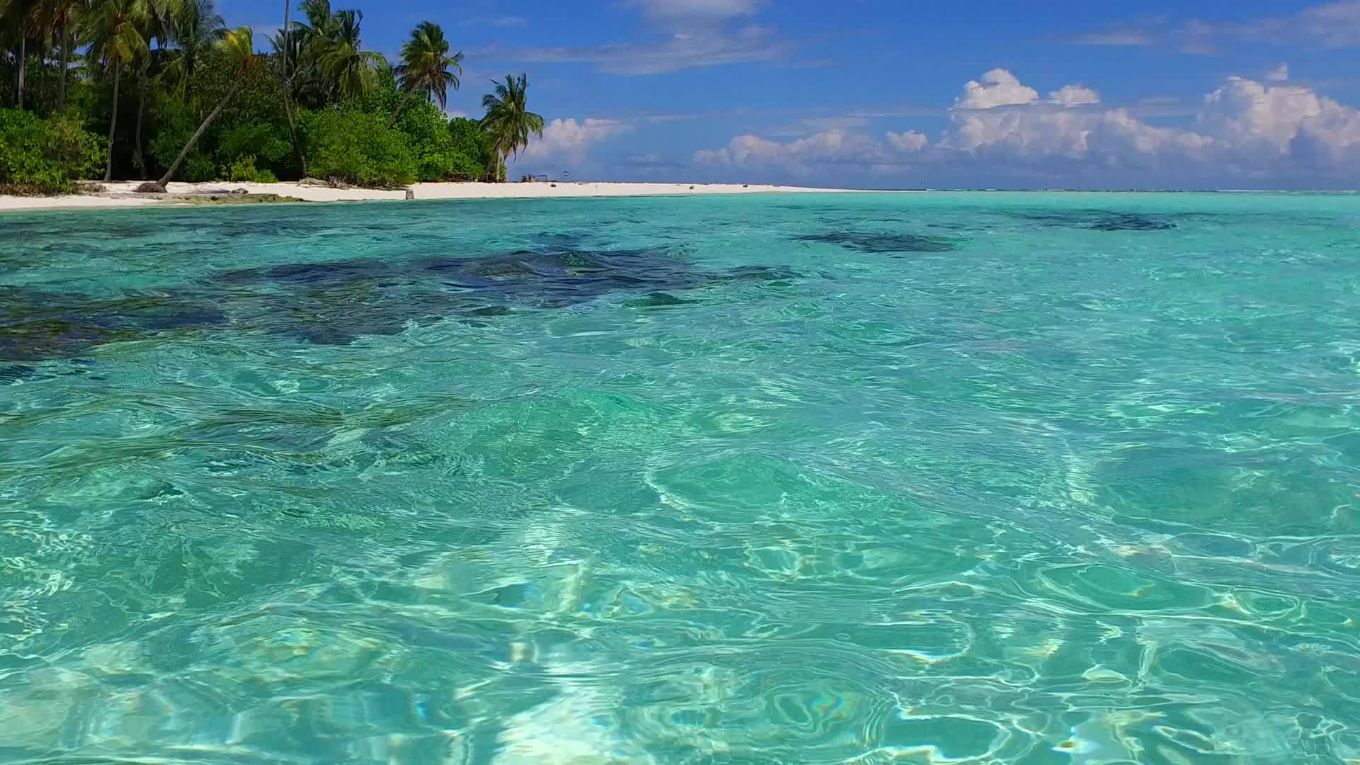在暗礁附近的蓝水和白沙的背景下近距离观看异国海岸线视频的预览图
